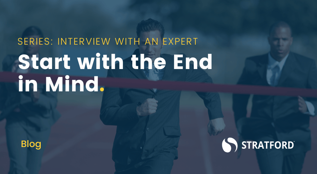 Three people in business suits running a race on an outdoor track with text overlay "Start with the End in Mind."